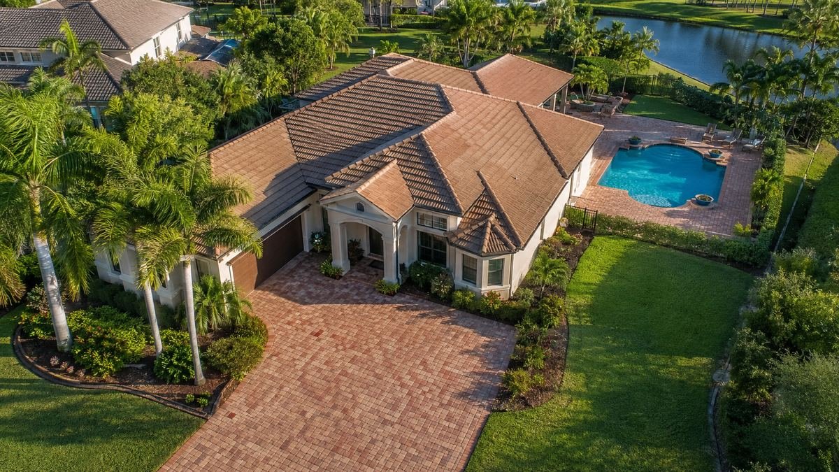Aerial view of Tampa home with paver driveway and pool deck