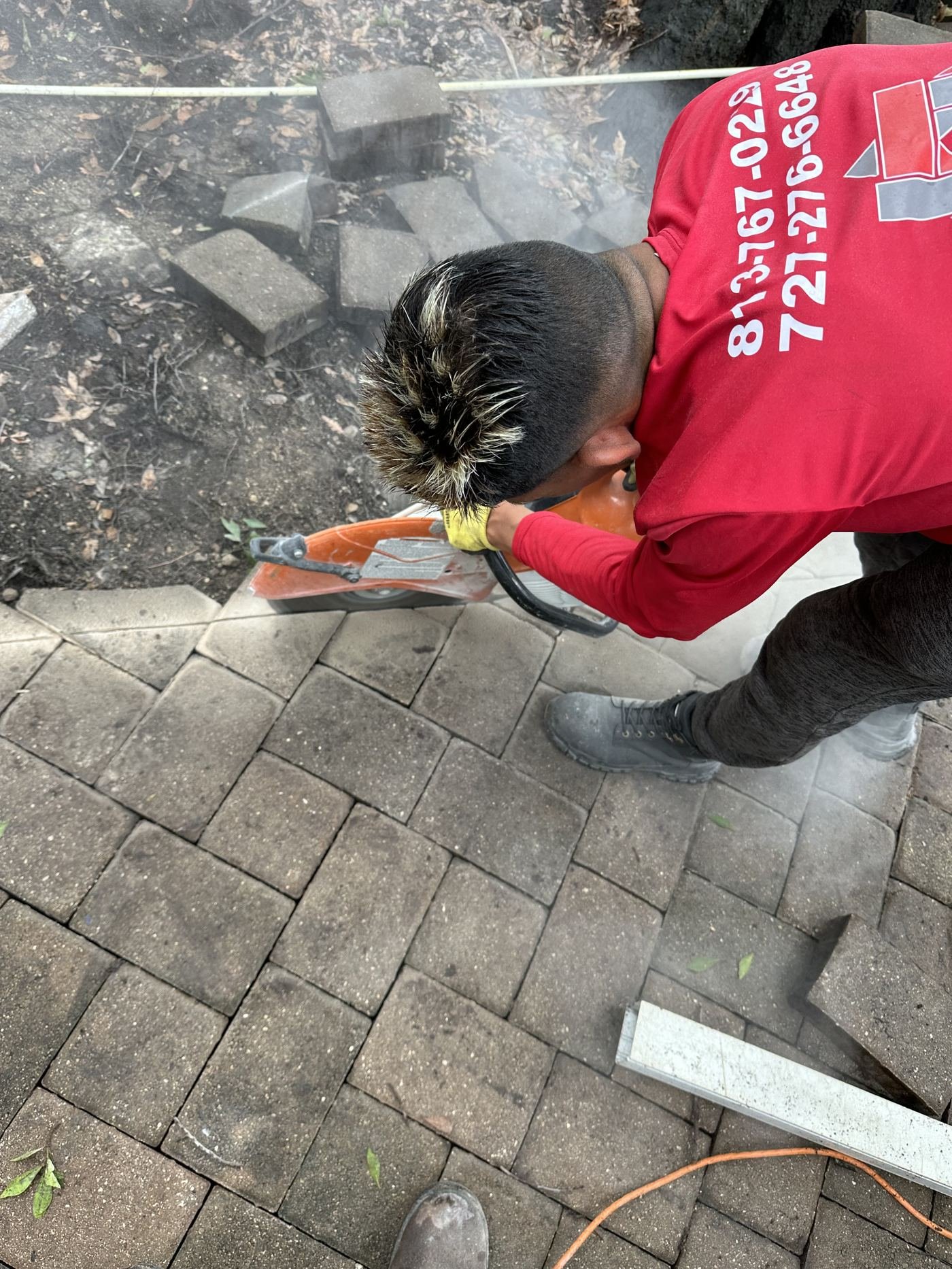 Crew member cutting paver on-site